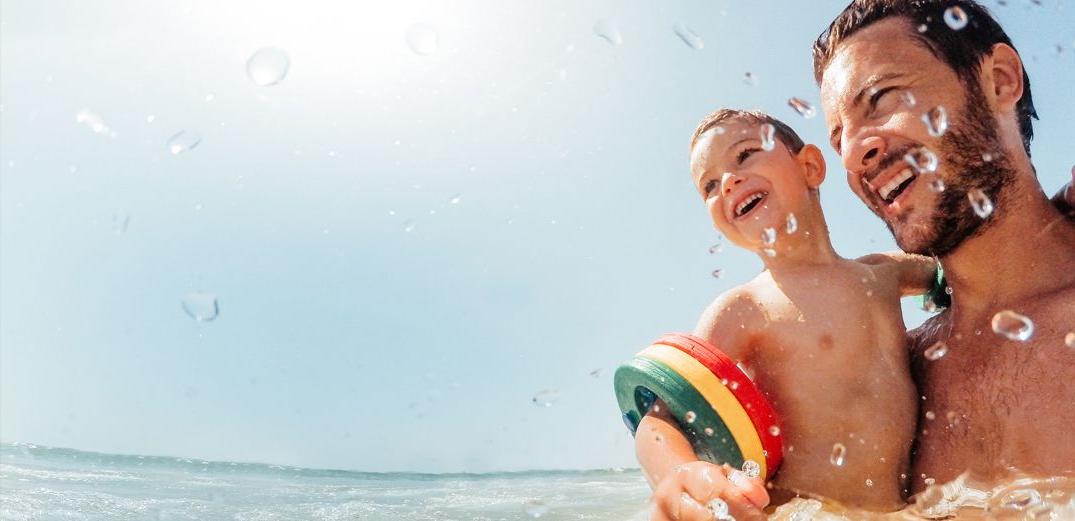 A young father and his son have fun swimming.